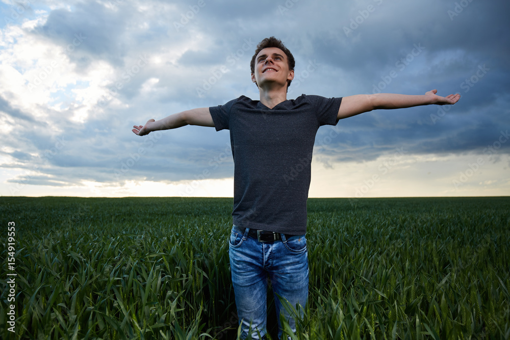 Teenager standing in a wheat field at sunset Teenager standing in a wheat field at sunset