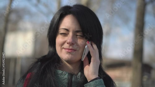 Beautiful Woman on the Phone Sitting on a Park Bench,close-Up photo