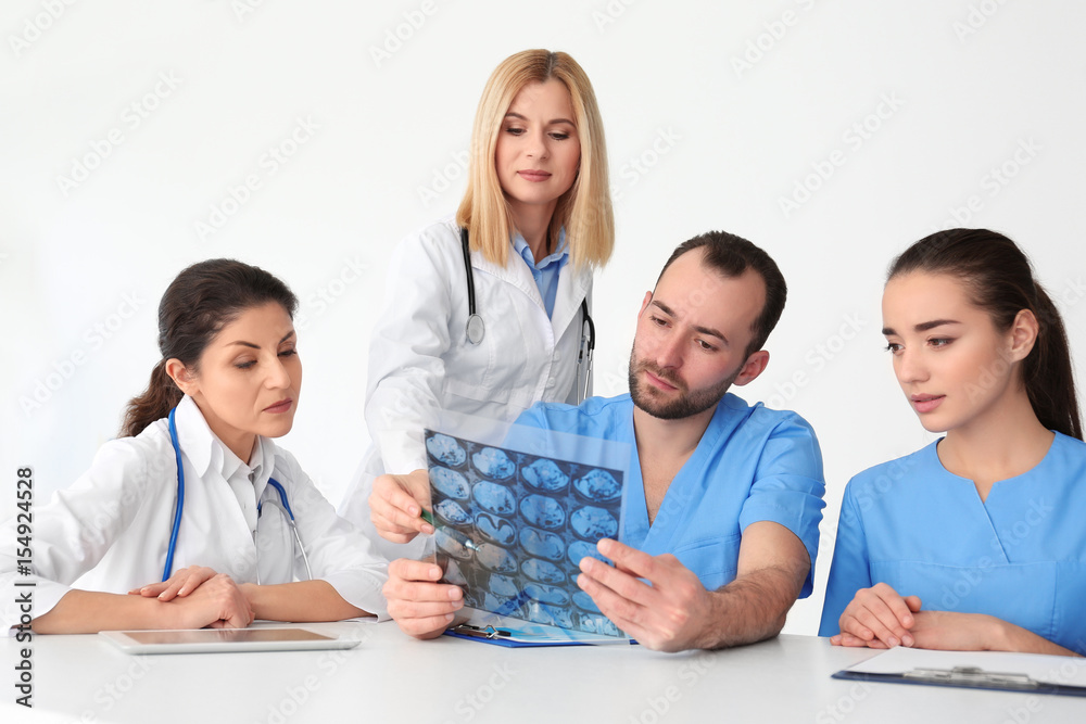 Team of doctors exploring roentgenogram at meeting Team of doctors exploring roentgenogram at meeting