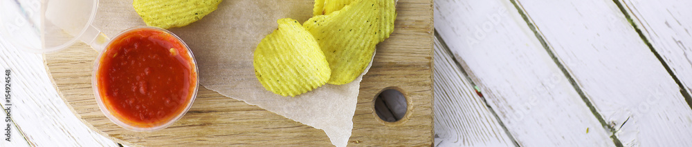 Horizontal bakground of potato chips on a table Horizontal bakground of potato chips on a table