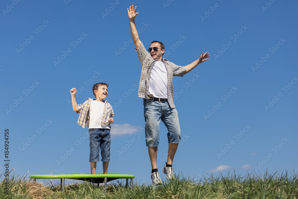 Father and son playing on the field at the day time.