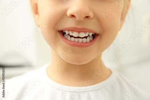 Smiling little child on light background, close up