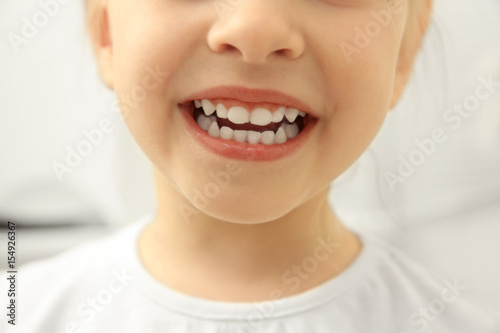 Smiling little child on light background, close up