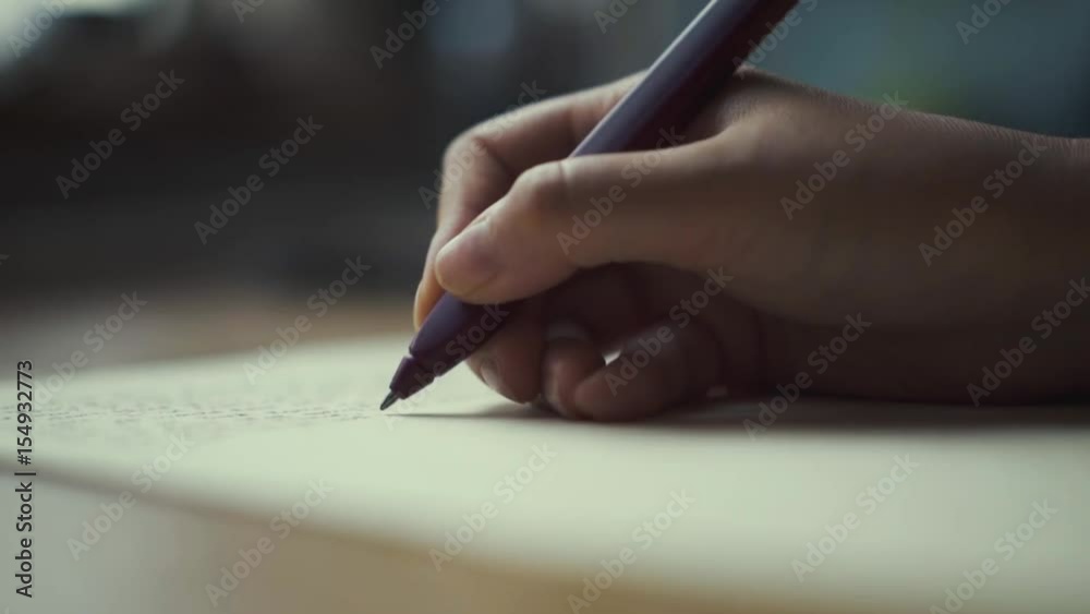 Hands of a woman writing on a piece of paper. Writing love letters.