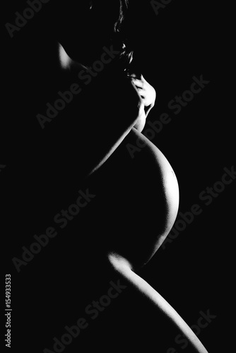 Naked pregnant woman covering her breast