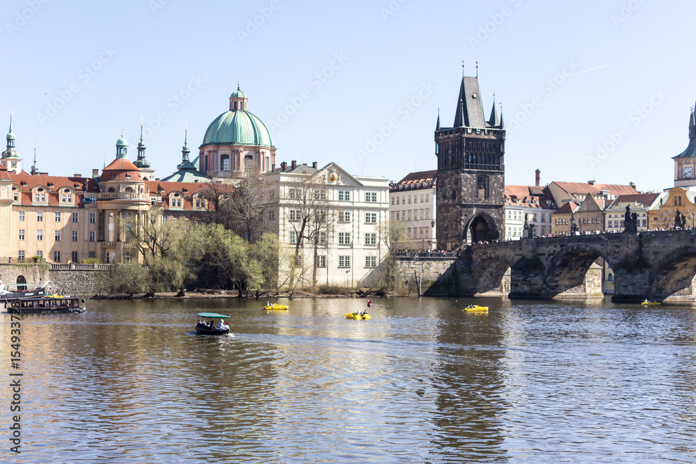 The view from the river Vltava to Charles Bridge and old town bridge tower . The old town district . Prague , Czech Republic .
