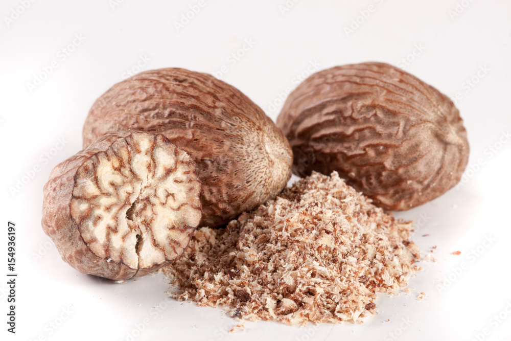 Three nutmeg and powder isolated on white background Three nutmeg and powder isolated on white background