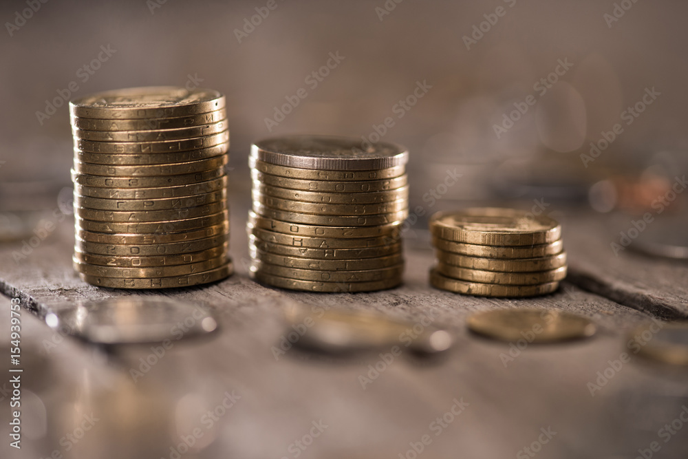 Stacks of coins on wooden tabletop, coins stacked concept Stacks of coins on wooden tabletop, coins stacked concept