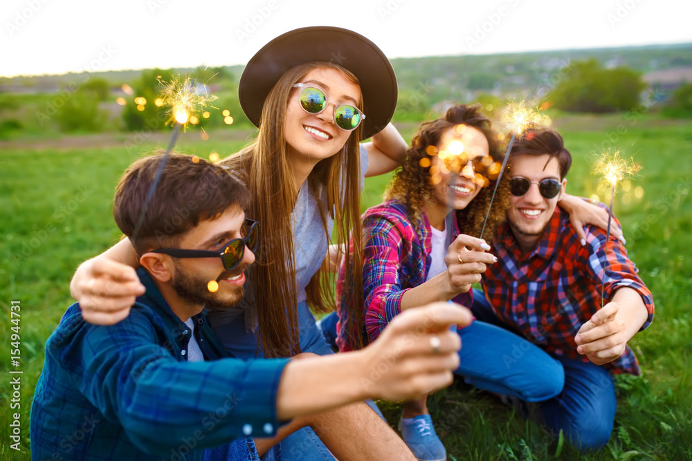 Fototapeta premium Grupa przyjaciół korzystających z party.people robi selfie. ludzie z zimnymi ogniami, każdy ma wspaniały nastrój. Czas letni.