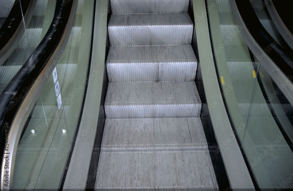 Fototapeta premium A picture taken from the bottom of an escalator that's going up.