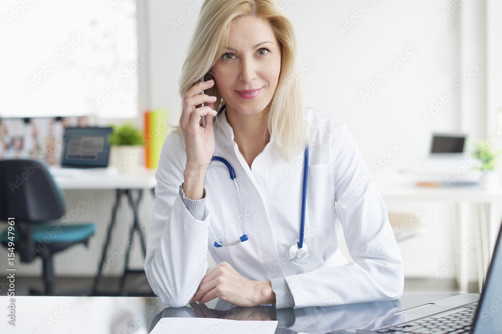 Female doctor discussing on mobile phone