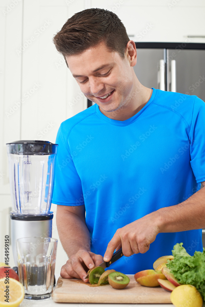 Male Athlete Making Juice Or Smoothie In Kitchen Male Athlete Making Juice Or Smoothie In Kitchen