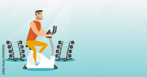Young man riding stationary bicycle.