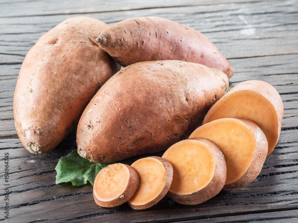Sweet potatoes on the old wooden table. Sweet potatoes on the old wooden table.
