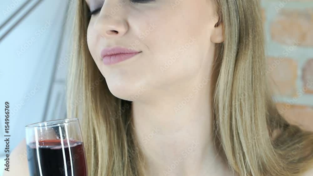 Pretty girl with strong makeup drinking red wine and smiling to the camera, steadycam shot
Pretty girl with strong makeup drinking red wine and smiling to the camera, steadycam shot