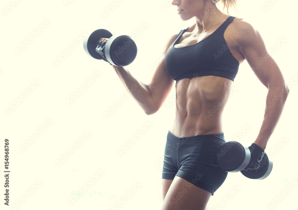 Muscular fitness woman posing with dumbbels on white background Muscular fitness woman posing with dumbbels on white background