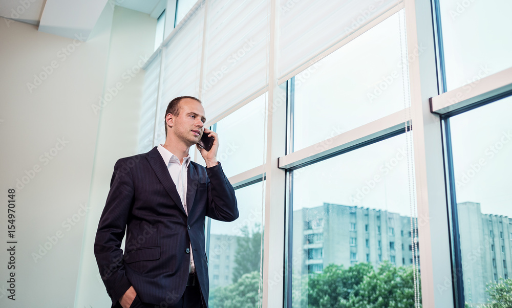 A businessman talking on a mobile phone,Businessman talking on the phone in office,Senior businessman,Portrait of businessman talking on mobile phone,business concept A businessman talking on a mobile phone,Businessman talking on the phone in office,Senior businessman,Portrait of businessman talking on mobile phone,business concept