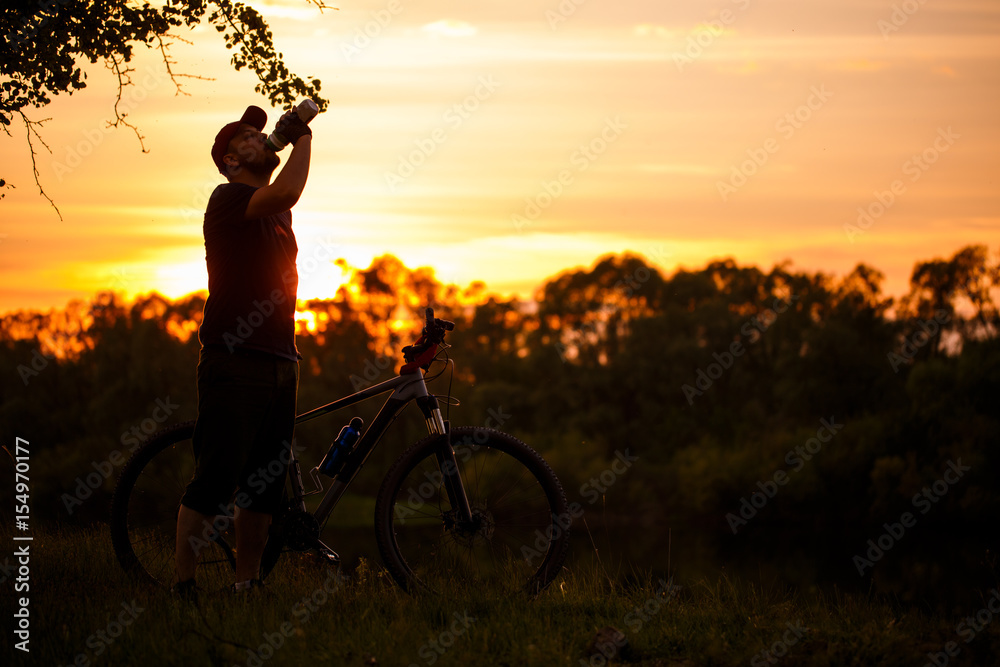 Εκτύπωση καμβά A bike ride at sunset is not the background of the river