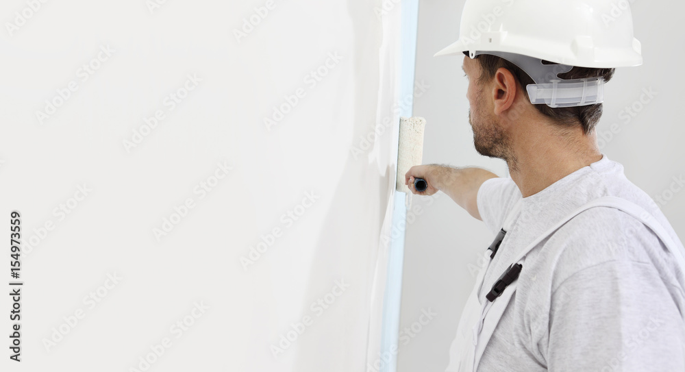 painter man at work with a paint roller, wall painting concept painter man at work with a paint roller, wall painting concept