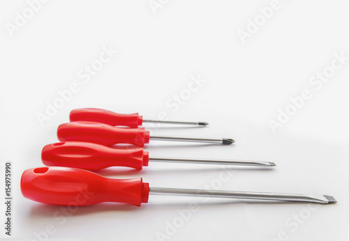 Four red shiny metal and plastic tool screwdriver for repair