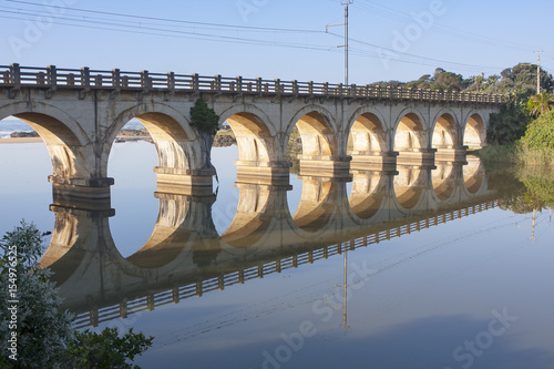 Reflection of a railway bridge crossing a calm lagoon on the KZN South Coast of South Africa.