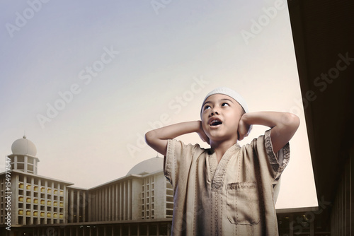 Canvas-taulu Little asian muslim boy wearing cap praying