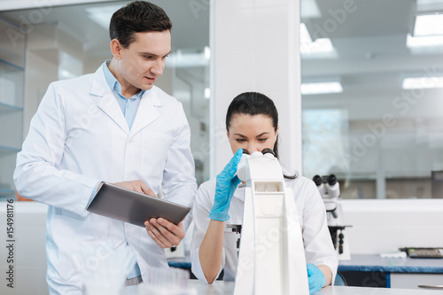 Attentive female scientist examining DNA chain