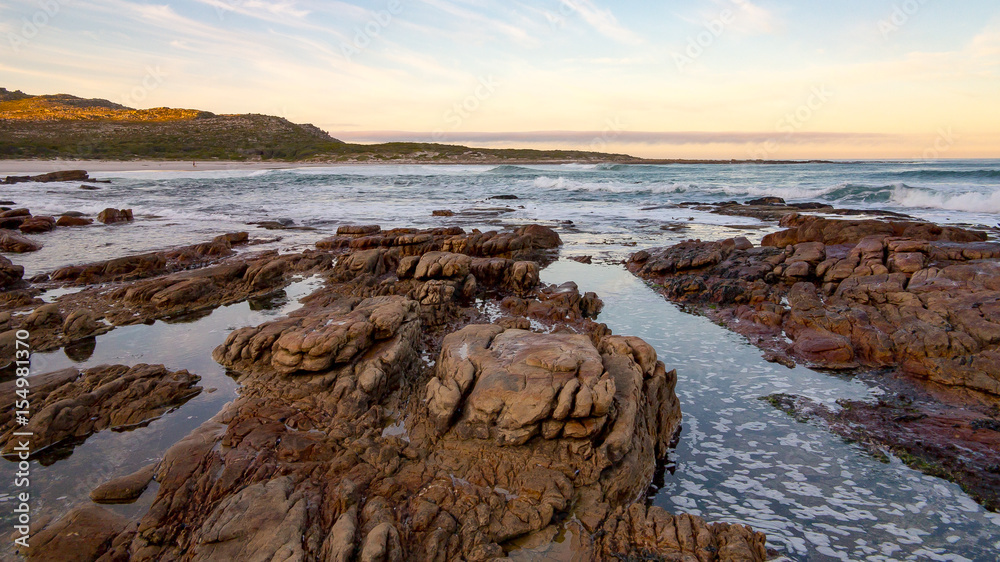 Early morning tide and surf at Scarborough on the Cape Peninsula in South Africa.  This photograph is a wide-angle shot of the rocks and surf on a calm morning.