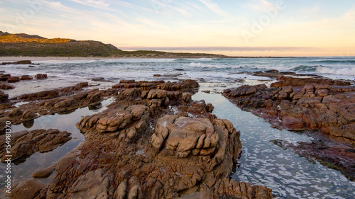 Early morning tide and surf at Scarborough on the Cape Peninsula in South Africa.  This photograph is a wide-angle shot of the rocks and surf on a calm morning. © Fred