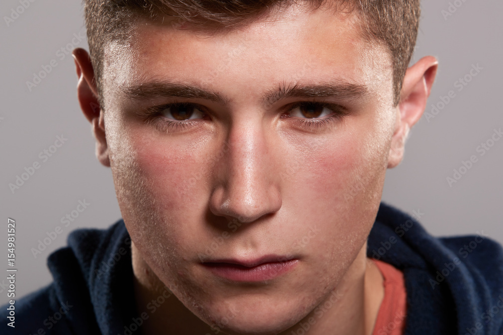 Obraz premium Teenage boy with serious expression, close up