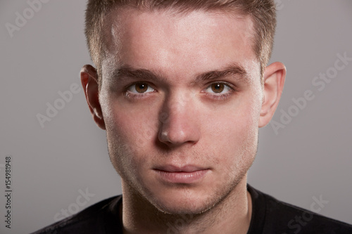 Young white man looking to camera, close up head shot