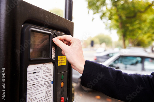 Obraz na plátně Close Up Of Man Putting Money In Parking Meter For Ticket