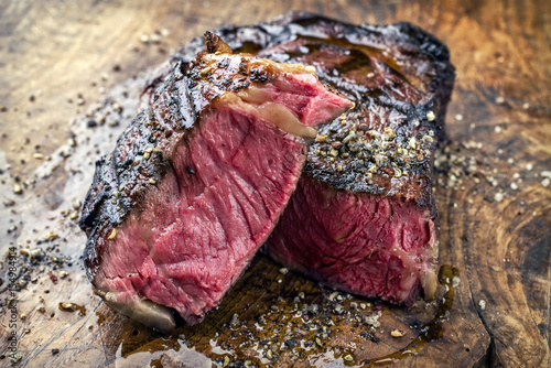 Barbecue aged Wagyu Rib Eye Steak as close-up on a wooden board photo