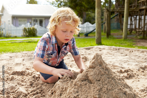 Bild auf Leinwand Male Pupil At Montessori School Playing In Sand Pit At Breaktime
