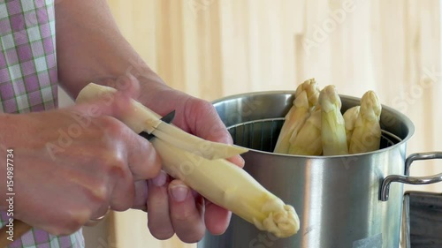 Peel asparagus - woman is peeling asparagus