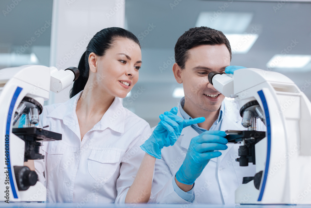 Attractive female practitioner pointing on objective lens Attractive female practitioner pointing on objective lens