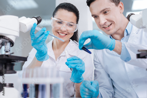 Konstfotografi Positive delighted lab assistants testing new reagent