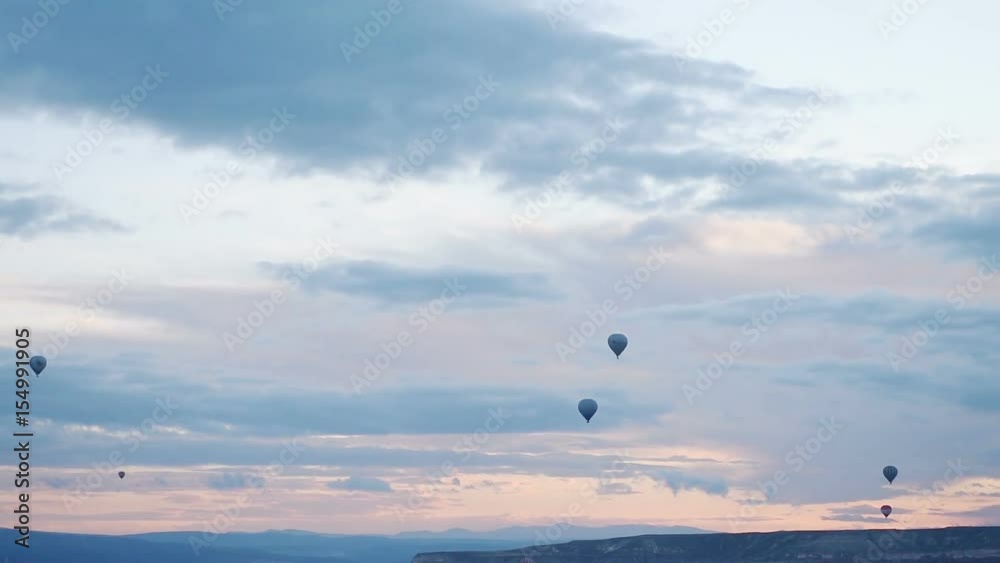 Hot air balloon flying over rock landscape at Cappadocia Turkey. Cappadocia with its valley, ravine, hills, located between the volcanic mountains in Goreme National Park. Hot air balloon flying over rock landscape at Cappadocia Turkey. Cappadocia with its valley, ravine, hills, located between the volcanic mountains in Goreme National Park.