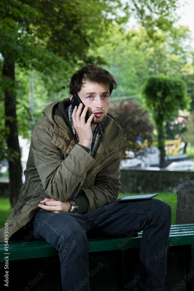 Man sitting on a wooden bench in the street Man sitting on a wooden bench in the street