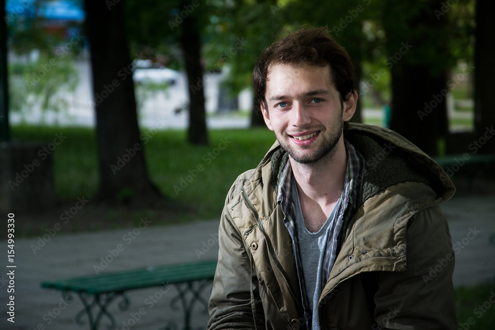 Handsome man outdoors portrait. Man smiling, looking in the camera Handsome man outdoors portrait. Man smiling, looking in the camera
