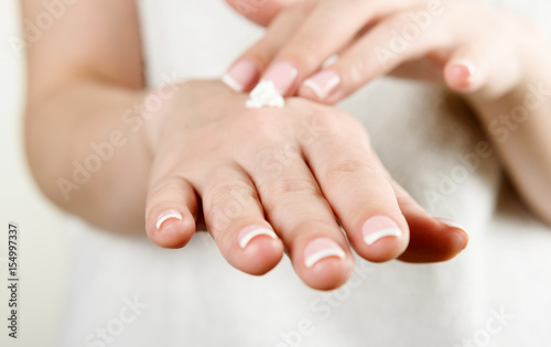 Beautiful woman's hands applying cream
