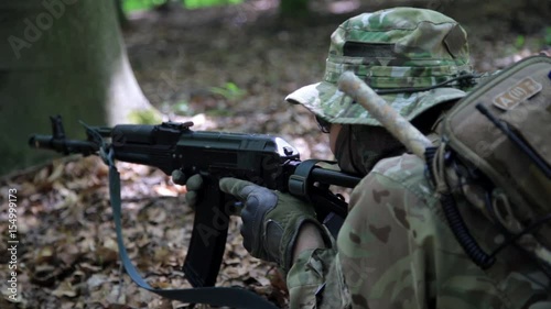 Guerilla partisan warrior aiming in forest ambush carrying his gun. Partisan war reconstruction.