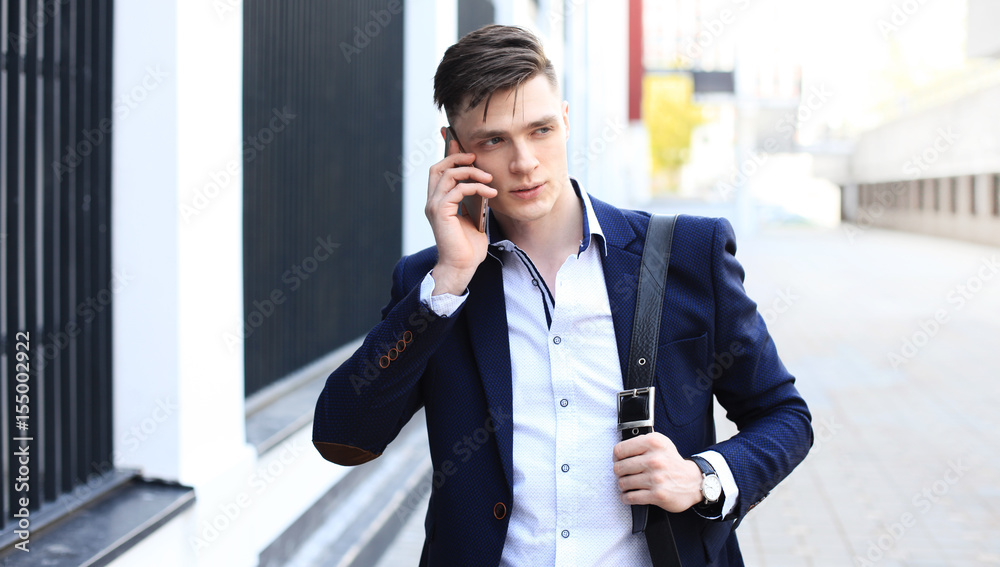 Young urban businessman professional on smartphone walking in street using mobile phone. Young urban businessman professional on smartphone walking in street using mobile phone.