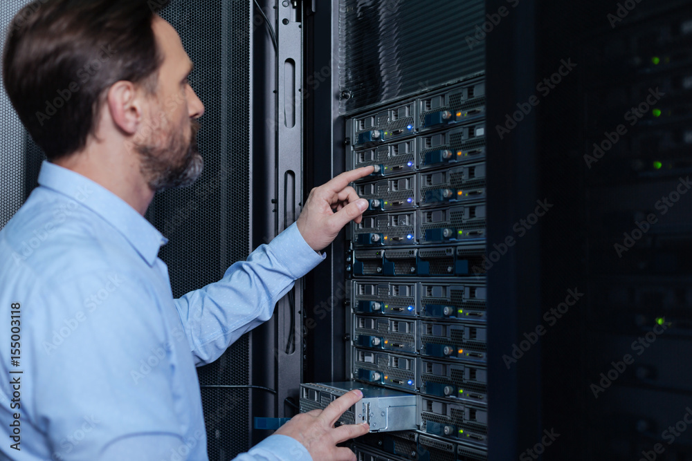 Nice bearded man setting up the network server Nice bearded man setting up the network server