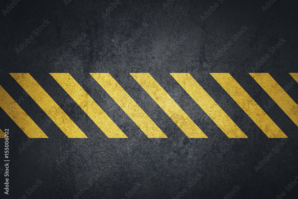 Fototapeta premium Old black grungy metal plate surface with yellow warning stripes