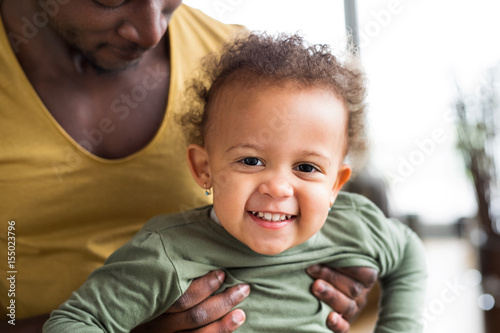 Unrecognizable afro-american father with his little daughter at 