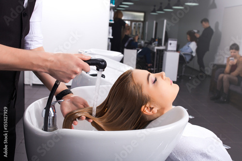The master washes the girl's head in the beauty salon