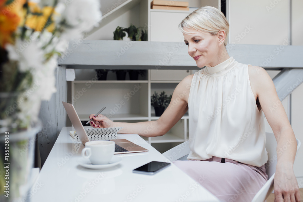 Woman using laptop in home office Woman using laptop in home office