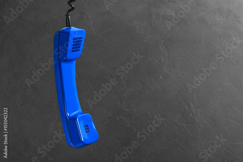 landline blue phone on a gray wall background photo