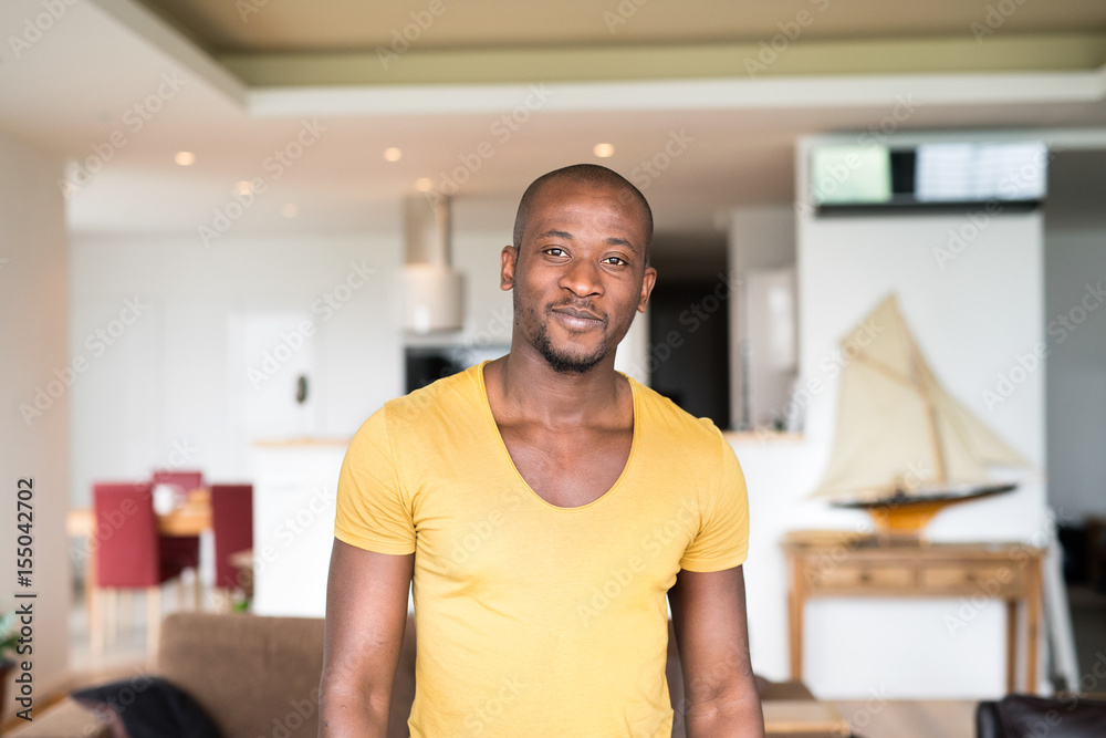 Young afro-american man in yellow t-shirt at home. Young afro-american man in yellow t-shirt at home.
